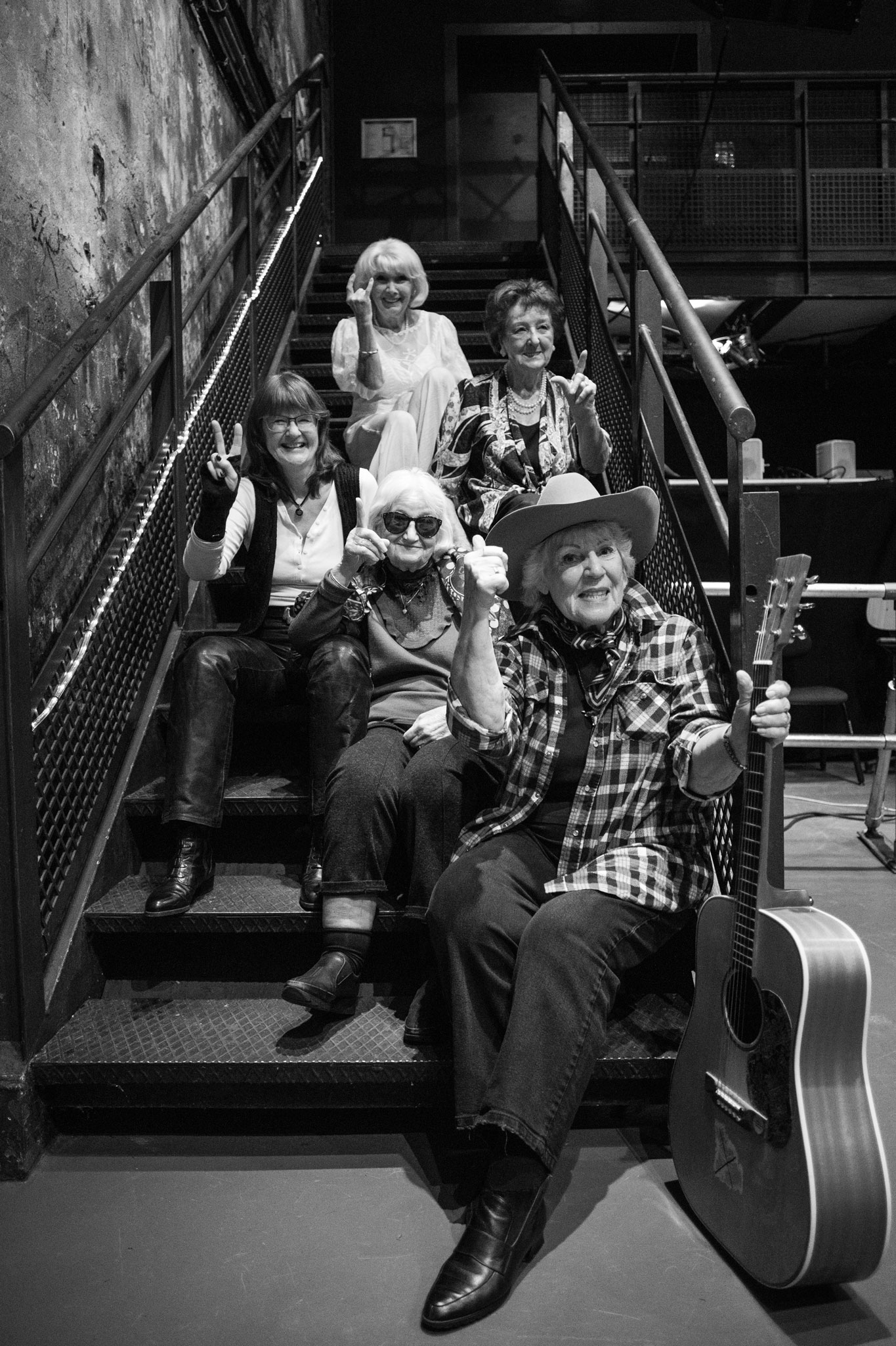 Fünf Seniorinnen sitzen lachend auf einer Treppe – Gruppenbild aus dem Projekt „Zeig dich, Alter!“
